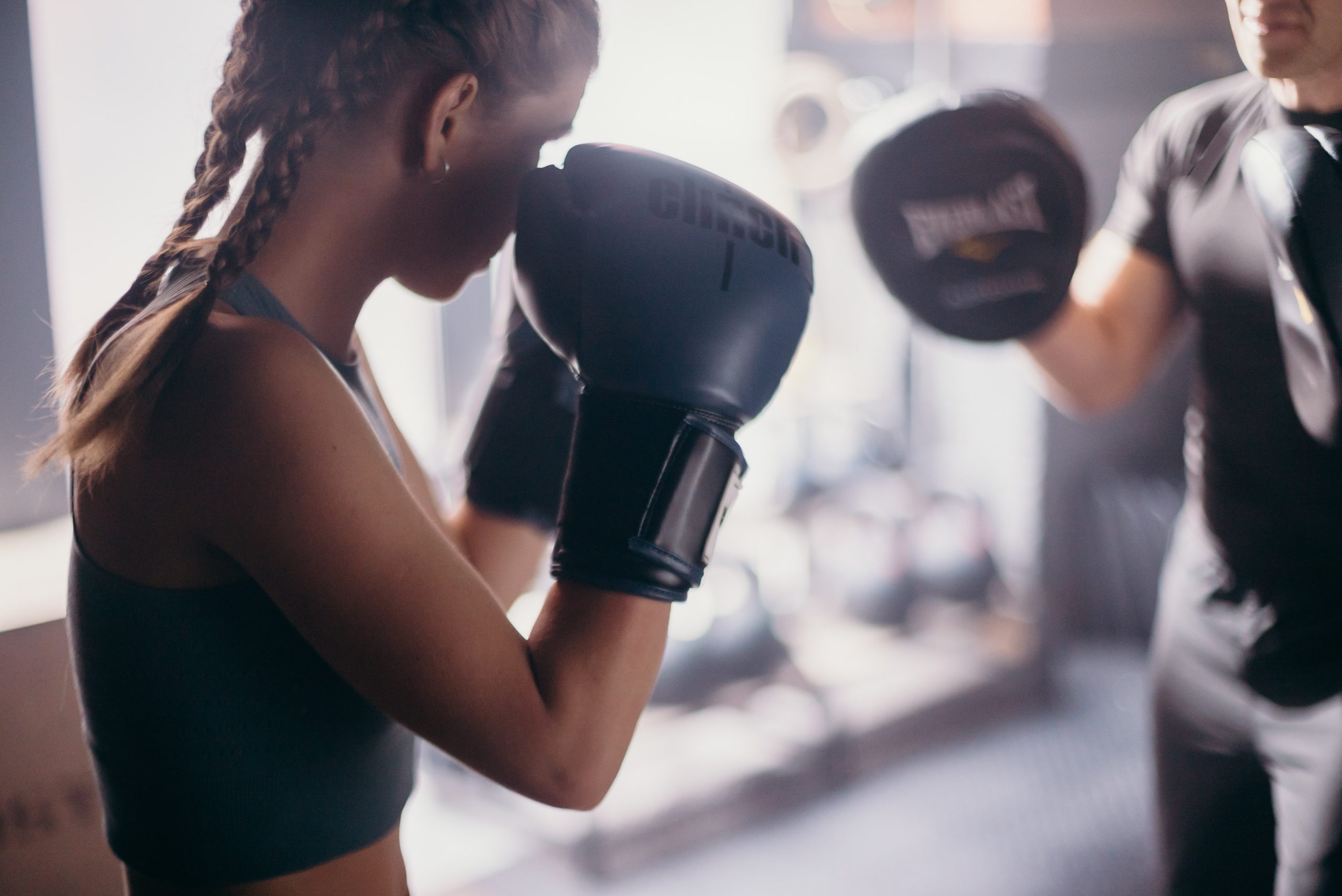 young woman sparring practice muay thai boxing gloves