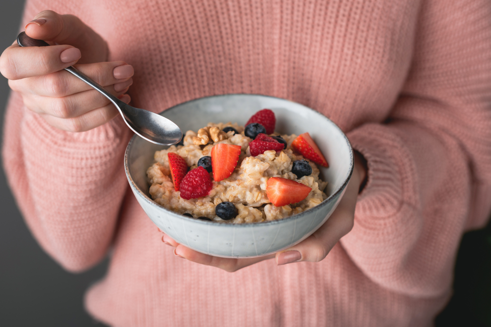 Woman,In,Cozy,Pink,Sweater,Eating,Oatmeal,Porridge,With,Berries.