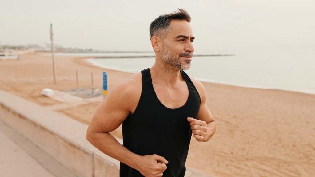 Middle-aged,Muscular,Man,Runs,Along,The,Promenade,Before,Jogging