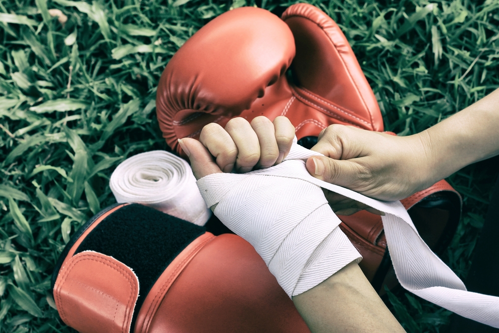Woman,Is,Wrapping,Hands,With,White,Boxing,Wraps,,Strong,Hand
