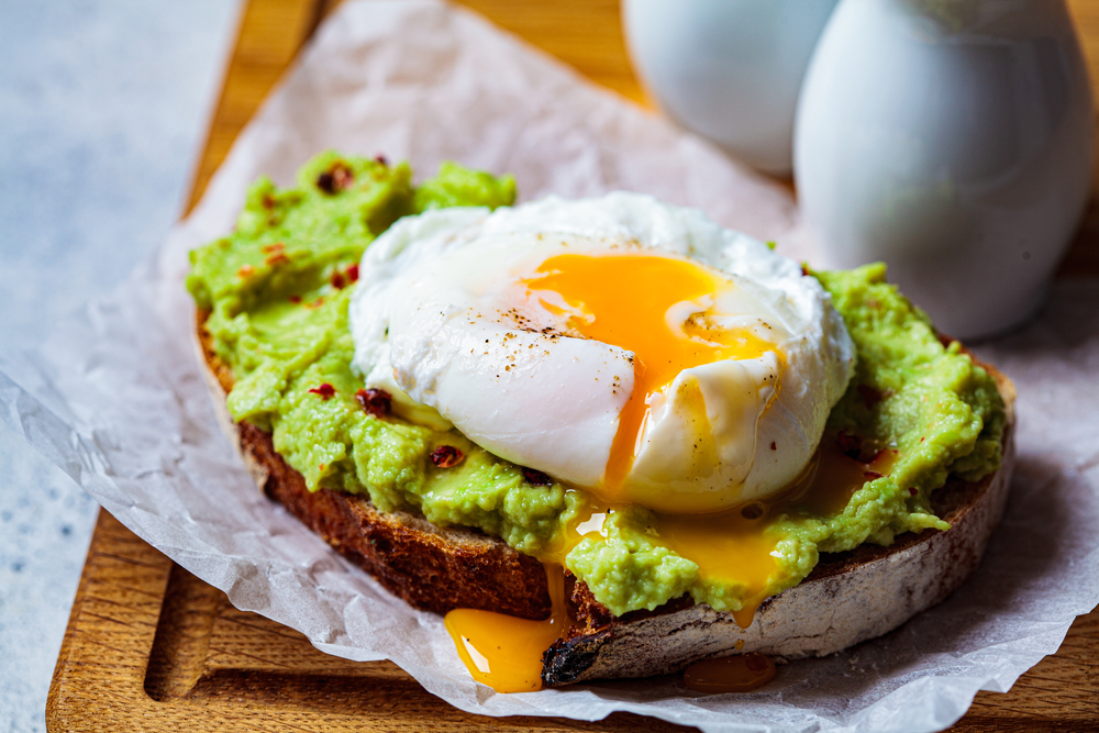 Avocado,Toast,With,Poached,Egg,On,A,Wooden,Board.,Breakfast